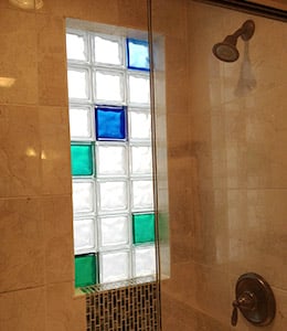 Bright green and blue colored glass blocks in a shower window - Innovate Building Solutions 