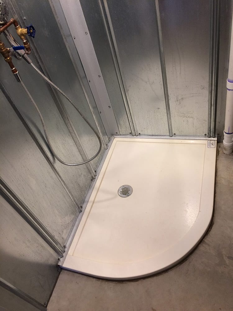 Arc shaped custom solid surface shower pan with metal corrugated wall panels 