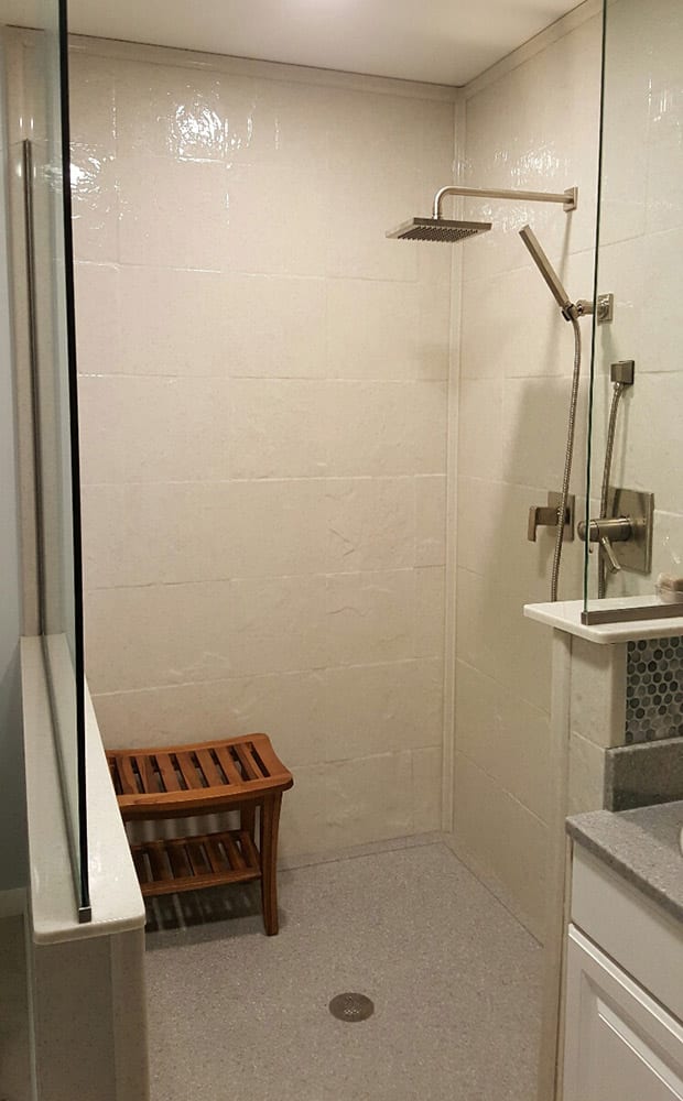 Stone tile cultured granite shower walls with a custom glass dividers for a walk in shower 